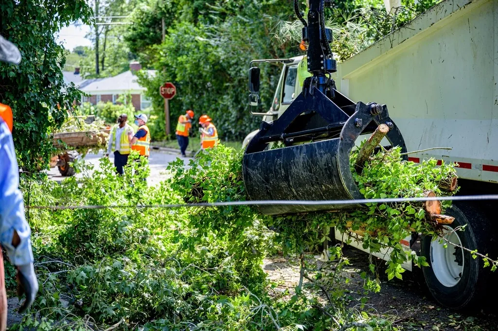 Grapple truck lifting a load of branches
